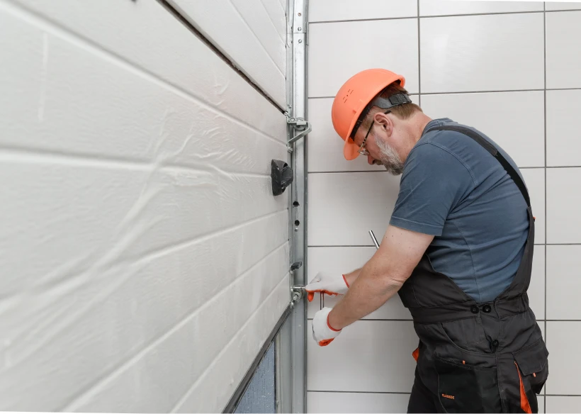Man in hard hat adjusting door components