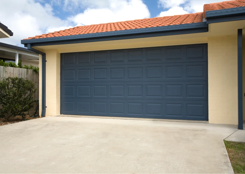 Blue garage door with orange tiled roof