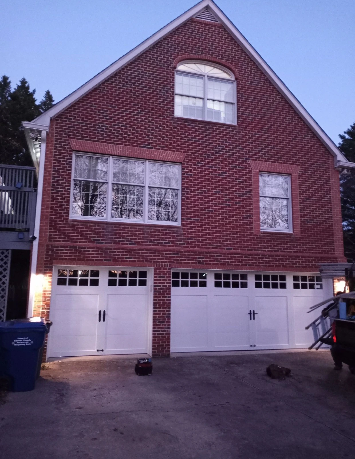 Red brick house with triple garage doors